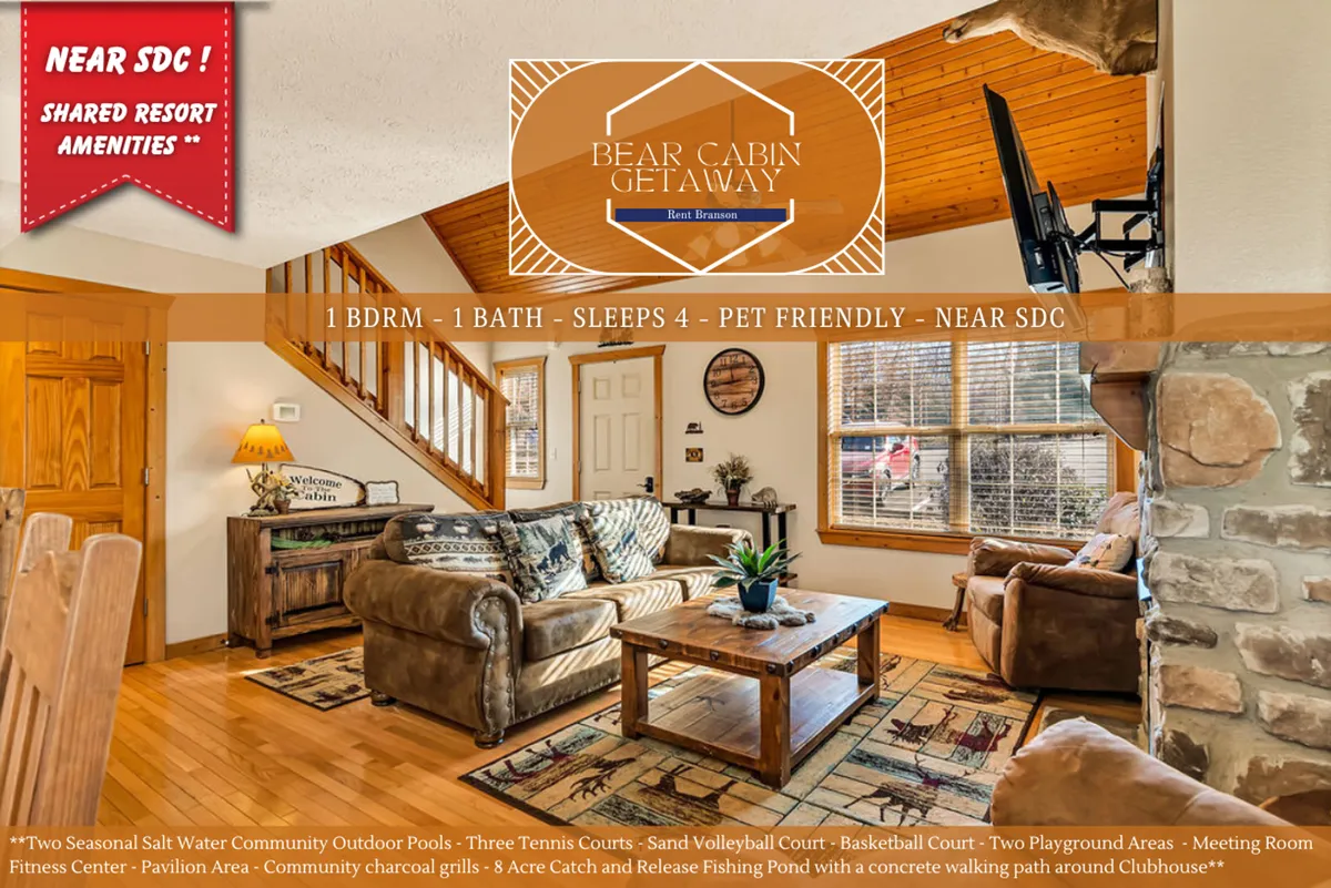 A warm and inviting living room featuring a stone fireplace, plush sofa, coffee table, a striking wooden staircase leading to a loft, and large windows that flood the space with natural light. The room is styled with cozy, rustic touches and offers space for relaxation or family gatherings.