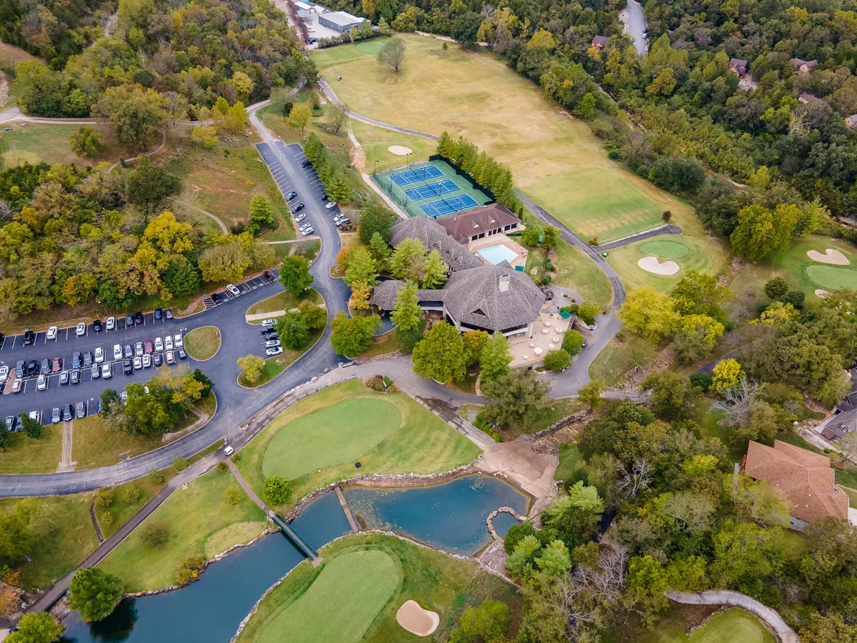 A vibrant overview of the resort’s amenities, including the golf course, swimming pool, tennis courts, clubhouse, and parking area, all surrounded by lush greenery. The image conveys the breadth of activities available and the sense of an active, welcoming community.